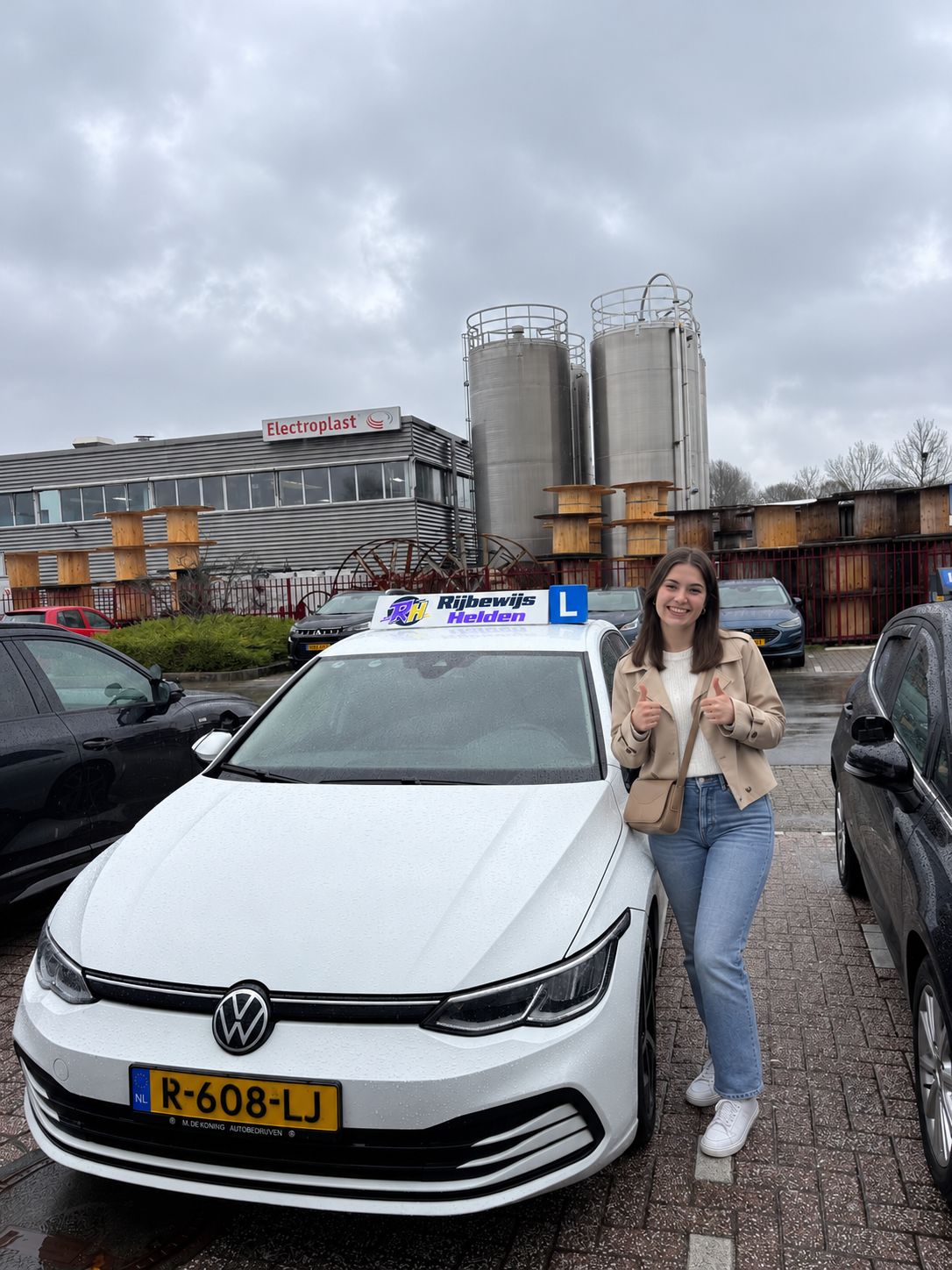 Passed with Rijbewijs Helden Student who passed, next to the Rijbewijs Helden driving school car in Dordrecht